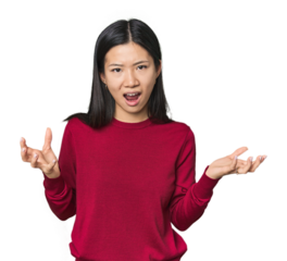 Young Chinese woman in studio setting screaming with rage.