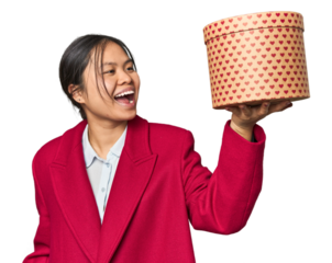 Young Chinese woman holding a heart-filled box raising fist after a victory, winner concept.