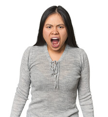 Young chinese woman isolated shouting very angry, rage concept, frustrated.