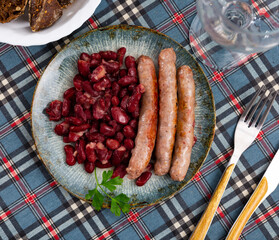 Traditional Catalan dish of fried pork sausage Butifarra with a side dish of beans