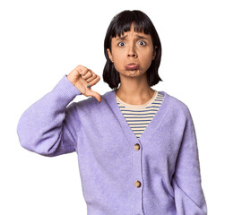 Young Hispanic woman with short black hair in studio showing a dislike gesture, thumbs down....