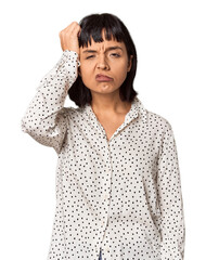 Young Hispanic woman with short black hair in studio tired and very sleepy keeping hand on head.