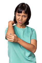 Young Hispanic woman with short black hair in studio massaging elbow, suffering after a bad movement.