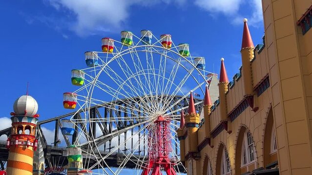 colourful Ferris wheel in Sydney amusement Theme Park with Sydney harbour Bridge in the background NSW Australia 