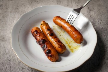 grilled sausages and fork on plate