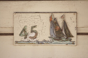 Old house number plaque with sail boats. number 45