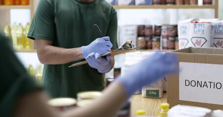 People, sorting and food for donation in shop, charity and community service with care in apartment. Volunteers, packing and employees by tin food, cans and giving to non profit foundation in support