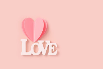 Fototapeta na wymiar Heart and word love, St. Valentine Day, love or wedding day concept. Cut pink paper heart and white wooden text love as symbol romantic relationships, pink color background, minimal flatlay