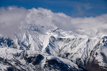 Obraz premium Stunning view of the Alps at the Meribel ski area in France. Sunny winter day, blue sky, clouds and peaks.