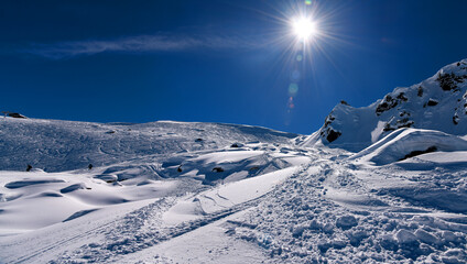 Amazing sunny day at the Meribel ski resort in France. Skiers exploring off piste areas with fresh...