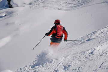 Dynamic photo of advanced skier downhill at the off piste area leaving fresh snow powder behind. Meribel ski resort in France.