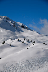 Ski tracks on the off piste terrain at the Meribel Ski Resort in France. Beautiful sunny day with blue sky.