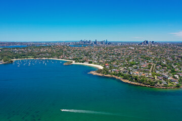 High angle aerial drone view of Balmoral Beach and Edwards Beach in the suburb of Mosman, Sydney, New South Wales, Australia. CBD, North Sydney in the background.