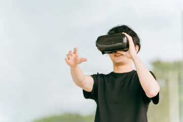 VRゴーグルをつけてバーチャルリアリティ・メタバースを体験する男性
