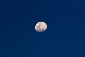 Naklejka na ściany i meble Moon in the dark blue sky, closeup of photo with selective focus