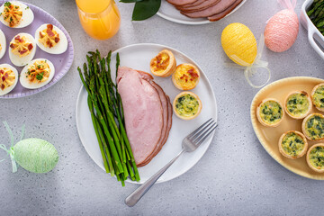 Easter brunch table with a potion of ham with asparagus on the plate