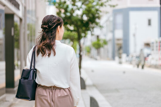 オフィス街を歩く・通勤するビジネスウーマンの後ろ姿（ワーキングマザー・ワーママ・観光）
