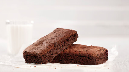 Freshly Baked Chocolate Brownies Paired With a Glass of Milk on a White Background