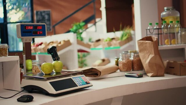 Supermarket electronic scale used to weight bulk items and organic freshly harvested produce, nonpolluting sustainable lifestyle. Empty grocery store selling homemade supplies. Handheld shot.