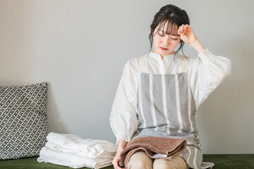 家事に疲れるエプロン姿の女性（共働き・疲労・家事分担）  © buritora