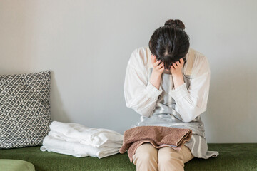 洗濯物をたたむ・家事にストレスをかかえる女性（泣く・限界・悩む・困る・嫌い）  © buritora