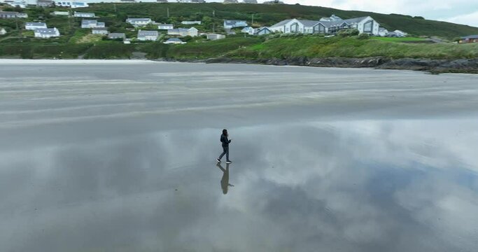 Woman walks along a deserted sandy beach alone in 4k