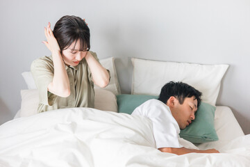 ベッドで夫のいびき・寝言で睡眠不足の妻
