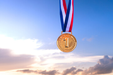 Gold medal symbolizing triumph on the podium against a golden sky adorned with sunset clouds. It represents the pursuit of victory and first place in sporting events