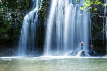 People at big waterfall in the green forest of Costa Rica