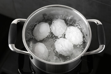 Fototapeta na wymiar Chicken eggs boiling in pot on electric stove, above view
