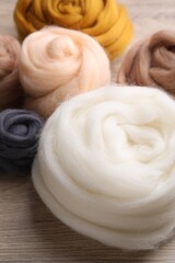Colorful felting wool on wooden table, closeup