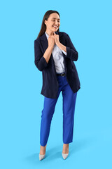 Young woman in stylish suit on blue background