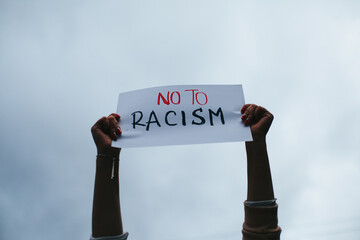 photograph of hands holding a sign with the phrase 
