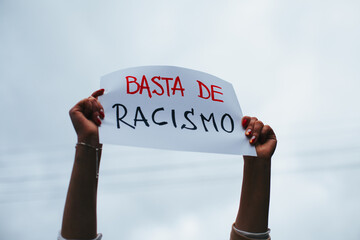 photograph of hands holding a sign with the phrase 