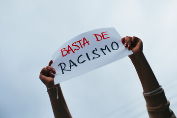 photograph of hands holding a sign with the phrase 