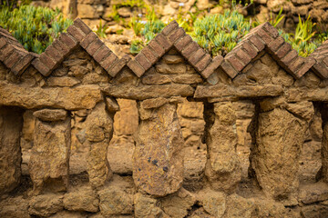 Beautiful brick fence near the house-museum in the Park Guell in Barcelona. Old architecture concept
