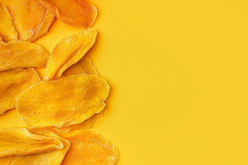 Naklejka premium Slices of dried mango on orange background