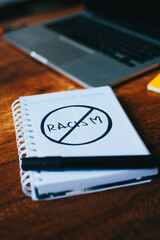 photograph of notebook with symbol of prohibition to racism on a table. 