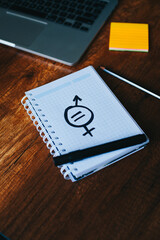 Photograph of notebook on a table with gender equality messages.