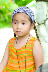 A cute little Asian girl in orange dress