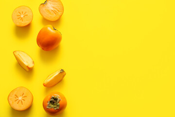 Many sweet ripe persimmons on yellow background