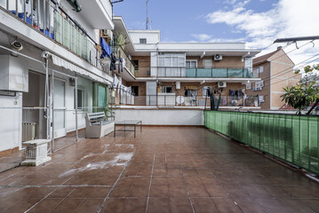 terrace of a residential house with brown stoneware floors and numerous balconies of other homes