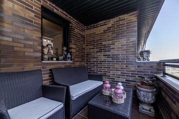 Small terrace with rattan furniture with decorative accessories
