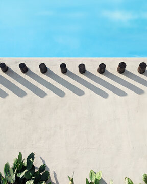Long shadows on an adobe wall with cactus