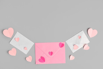 Envelopes with paper hearts on grey background