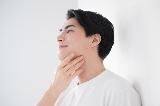 Asian (Japanese) man touching cheek Fresh image of hair removal and skin care Close-up For men's beauty and beauty