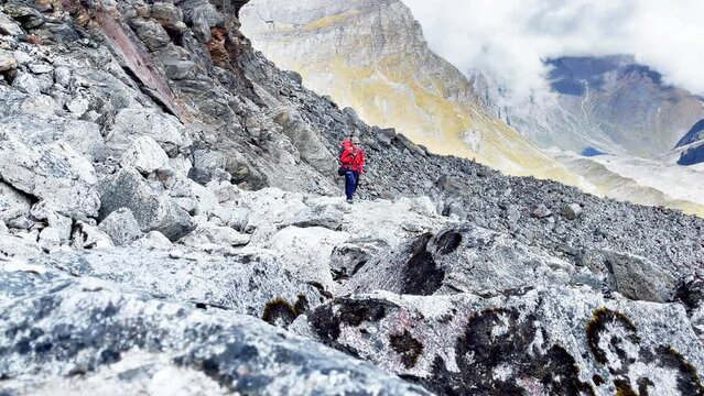 Two expedition members with backpacks together following Makalu Barun Park trekking route near Khare. Mera peak climbing acclimatization walk. Backpackers using trekking poles, enjoying valley view.