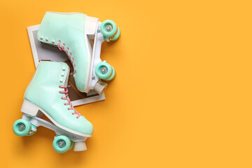 Composition with pair of vintage roller skates and magazine on orange background