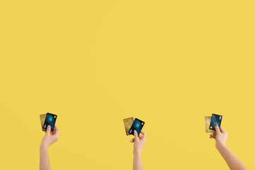 Women with credit cards on yellow background