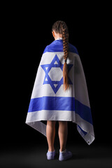 Little Jewish girl with flag of Israel on black background, back view. International Holocaust...